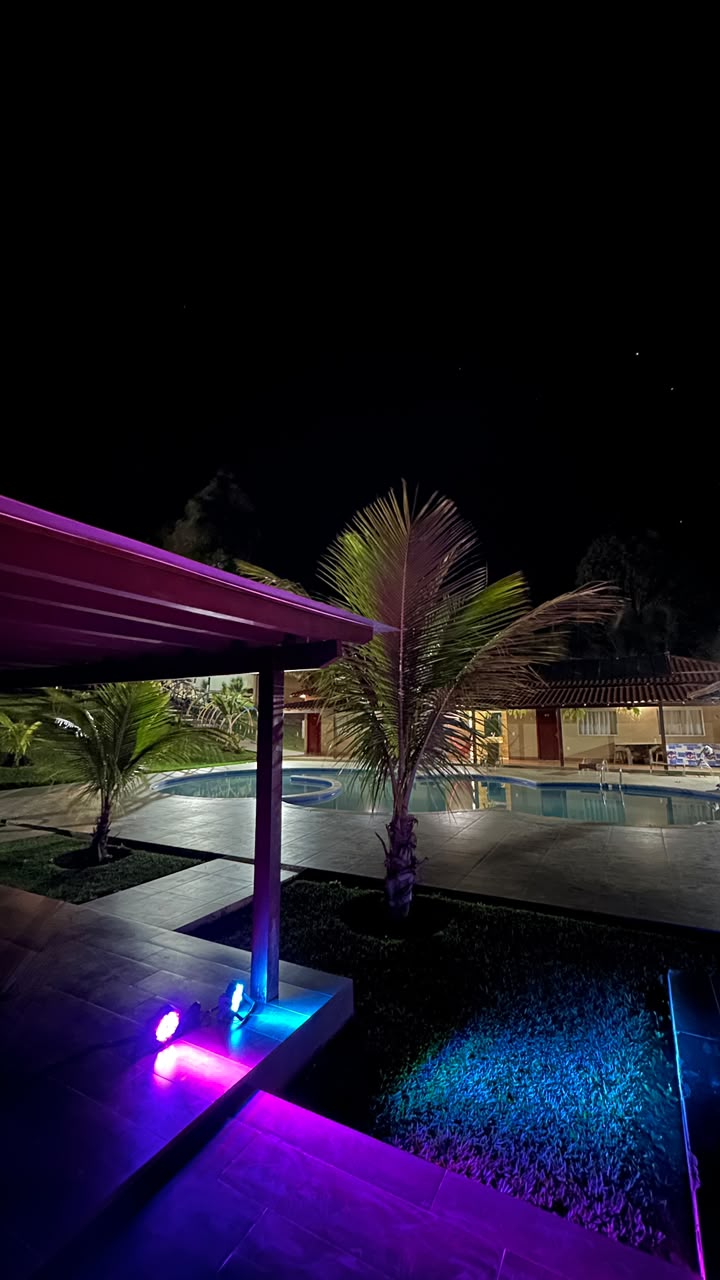 Piscina e jardins iluminados durante a noite